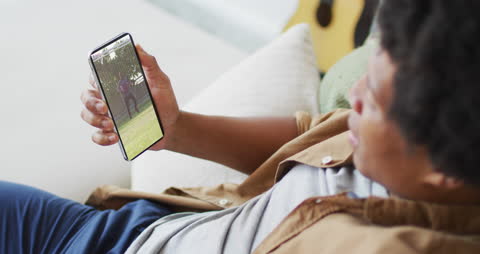 Afro American Man Watching Soccer Video on Smartphone at Home