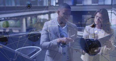 Two professionals analyzing digital network with futuristic overlay