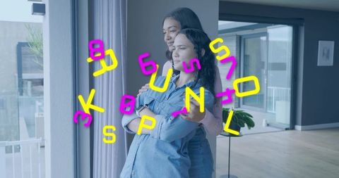 Women embracing and gazing through glass doors with neon letter overlay in apartment