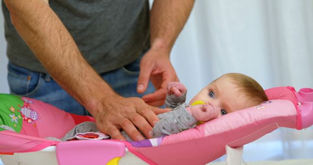 Father Adjusting Baby in Pink Infant Seat at Home - Download Free Stock Images Pikwizard.com