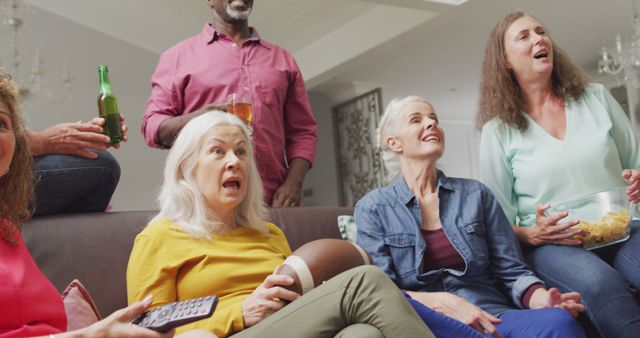 Group of friends excitedly watching television in a living room, suggesting an engaging and lively get-together. Suitable for use in content related to social gatherings, friendship, weekend leisure activities, celebrating life's moments, and diverse communities. Perfect for marketing materials, websites, and promotional content involving social interactions and home-related themes.