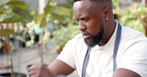 Male Gardener Organizing Plants in Outdoor Nursery