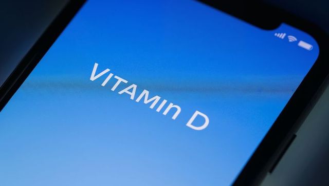 Smartphone displaying vitamin d app on blue gradient screen with minimalist interface