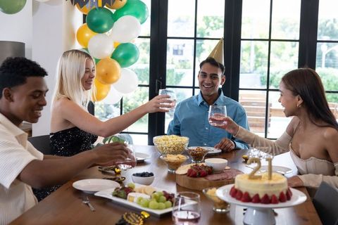 Diverse Friends Celebrating Birthday Around Elegant Table