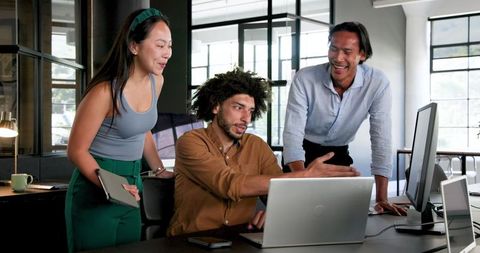 Diverse Colleagues Collaborating Around Office Computer