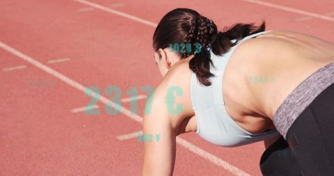 Female sprinter crouching at starting line on red track with teal data overlay