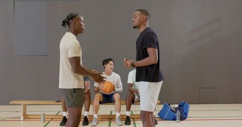 African american teammates shaking hands on gym court showing team camaraderie