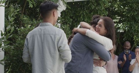 Friends embracing and celebrating at joyful wedding ceremony