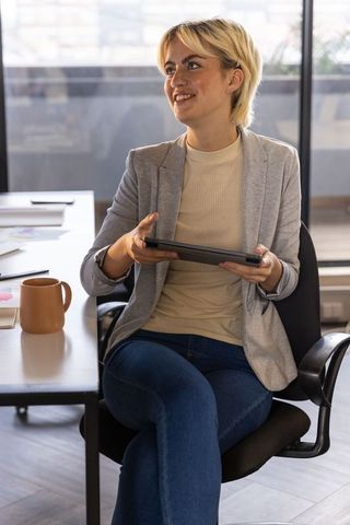 Professional woman with tablet in modern workspace