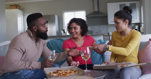 Friends Enjoying Pizza and Wine Together at Home