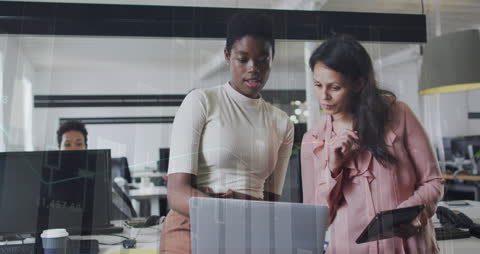 Businesswomen Analyzing Financial Data on Computer in Modern Office