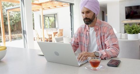 Remote Worker Focused on Laptop in Modern Home Office Setting