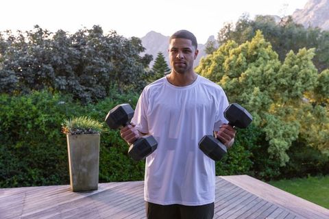African American Male Exercising with Dumbbells Outdoors