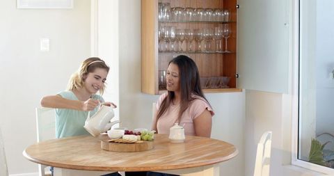 Celebrate multiracial friendship and pregnancy announcement in bright kitchen
