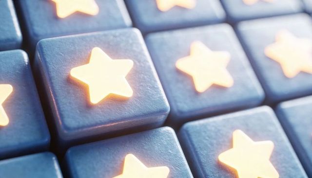 Glowing star buttons on slate-blue tile grid emitting warm light macro close-up