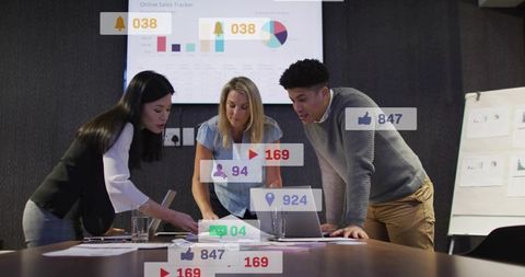 Team Collaborating and Analyzing Social Media Metrics with Charts and Laptop in Boardroom