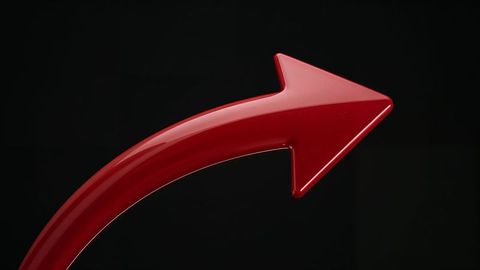 Glossy red curved arrow curving against black background for directional themes