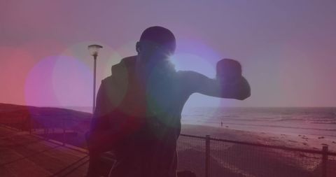 Athletic Man Running and Punching in Vibrant Beach Sunset