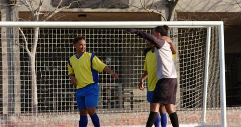 Confident Soccer Players Celebrating in Front of Goalpost