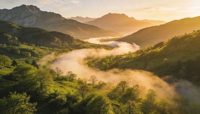 Winding fog ribbon glowing through sunlit mountain valley at dawn, golden meadows and ridgelines