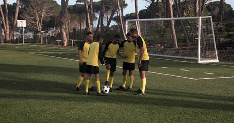 Soccer Team Strategizing Before Match on Sunny Field