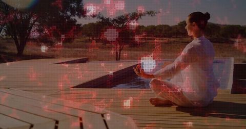 Woman Meditating on Pool Deck Wearing White Loungewear with Red Digital Grid Overlay