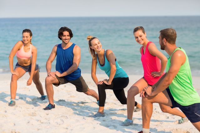 Group of friends stretching on beach, engaging in fitness activities. Ideal for promoting healthy lifestyle, outdoor workouts, fitness classes, and summer activities. Perfect for use in advertisements, social media posts, and fitness blogs.