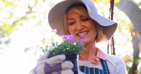 Mature woman joyfully tending garden plants