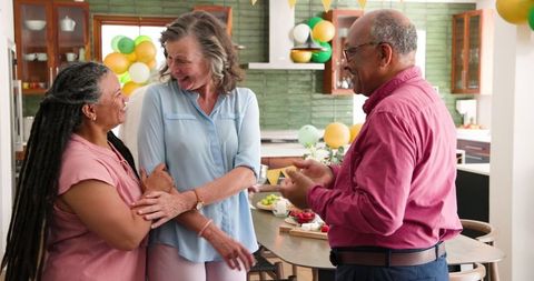 Senior Friends Joyfully Socializing Before Celebration Dinner Party