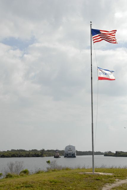 CAPE CANAVERAL, Fla. ---  A tugboat tows the Pegasus barge through the turn basin in the Launch Complex 39 Area at NASA's Kennedy Space Center.  The flag at right signifies that space shuttle Endeavour is still on orbit on the STS-123 mission.  The barge is carrying external tank No. 128 for space shuttle Discovery's STS-124 mission. After offloading, the tank will be transported to the Vehicle Assembly Building. On the STS-124 mission, Discovery will transport the Kibo Japanese Experiment Module - Pressurized Module and the Japanese Remote Manipulator System to the International Space Station. Discovery is targeted for launch on May 25.  Photo credit: NASA/Dimitri Gerondidakis