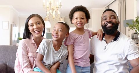 Joyful family sitting together in modern living room