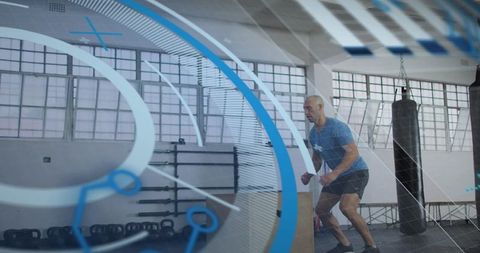 Athlete performing plyo box jump in industrial gym with kettlebells and punching bag