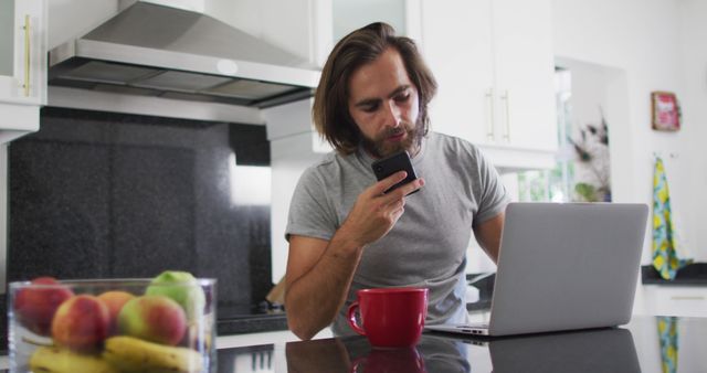 Man Working Remotely From Kitchen With Laptop and Phone - Download Free Stock Images Pikwizard.com