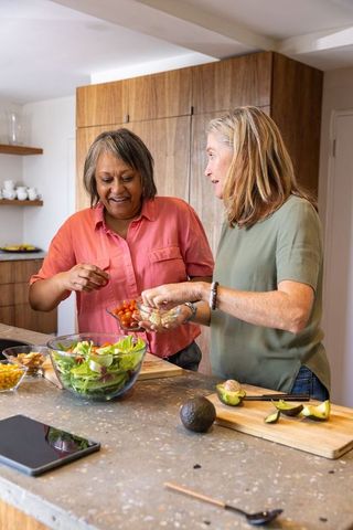 Diverse Friends Bonding While Preparing Healthy Salad in Modern Kitchen