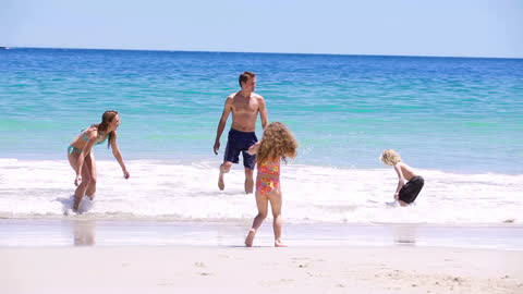 Family Enjoying Playful Fun at Sunny Beach