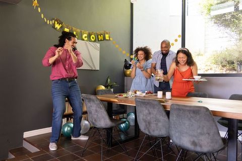 Joyful Friends Gathering Around Festive Dinner Table at Home