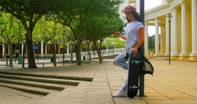 Fashionable Young Woman Posing with Skateboard in Urban Park - Download Free Stock Images Pikwizard.com