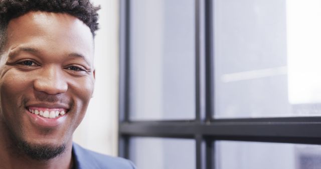 Cheerful Young Man Smiling by Window in Office - Download Free Stock Images Pikwizard.com