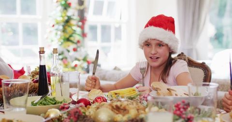 Girl Wearing Santa Hat Excited for Christmas Lunch Celebration