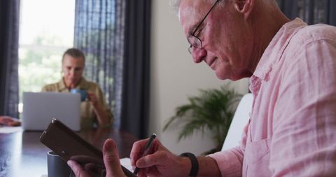 Senior Man Working on Digital Tablet at Home
