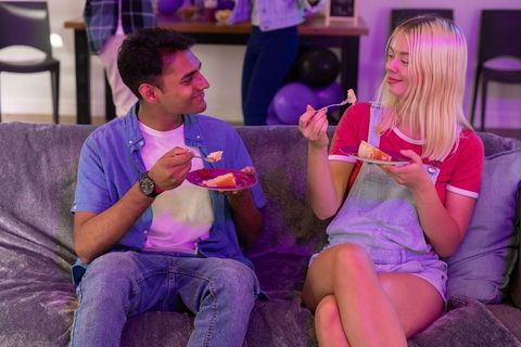 Diverse young couple enjoying cake during celebration at home