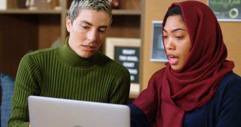 Diverse couple collaborating online together in cozy home environment