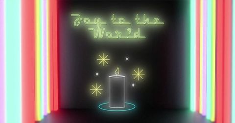Neon candle glowing on dark interior with joy to world script and colorful light bars