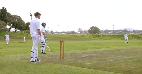 Cricket team players preparing for match on field