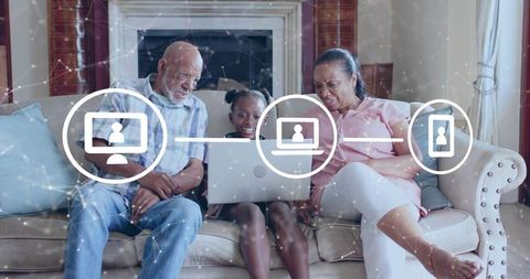 Multigenerational family connecting online on laptop, senior grandparents and granddaughter