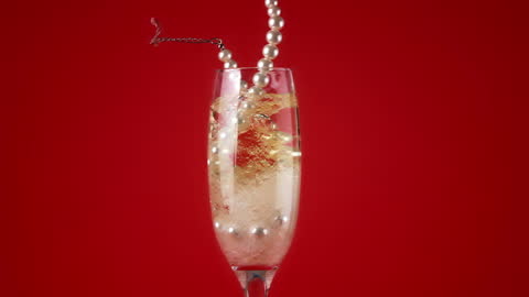 Floating Pearls in Champagne Flute with Red Background
