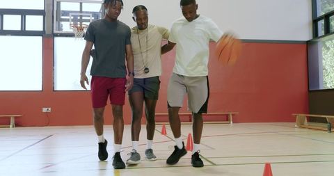 Basketball coach guiding players through dribbling drill to build agility and teamwork