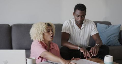 Friends Collaborating at Home, Discussing Ideas with Laptop and Notebook