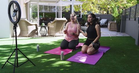 Diverse women filming outdoor workout session with ring light