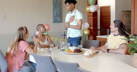 Diverse Friends Socializing Around a Dining Table with Refreshments